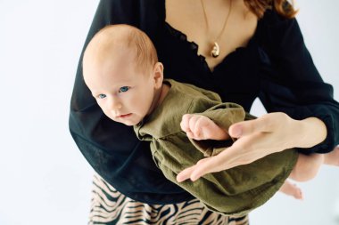 Güzel, genç bir anne, küçük çocuğuyla sevgi dolu bir şekilde etkileşime geçer ve yakın bağlarını gösterir..