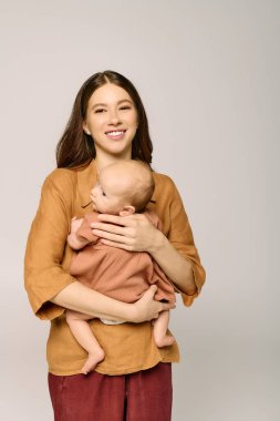 Genç bir anne sevgiyle bebeğini kucağına alır. Sıcak bir atmosferde sıcaklık ve mutluluk saçar..