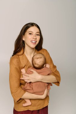 Anne sevgiyle küçük çocuğunu sevgi ve şefkatle dolu sıcak, davetkar bir yere yatırır..