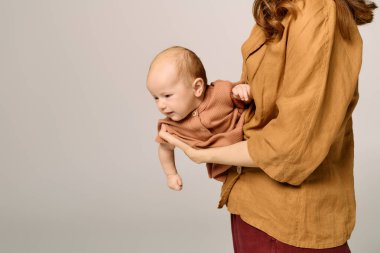 Nazik bir kucaklama, genç bir anne ile bebeği arasındaki bağı yakalar. Sevgi ve neşeyi gösterir..