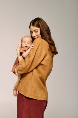 Güzel, genç bir anne, çocuğunu sevgiyle kucaklıyor ve birlikte hassas bir anı paylaşıyor..