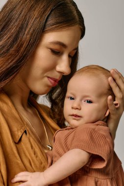 Genç bir anne sevgi dolu bir şekilde çocuğunu sıcak, modern bir ev ortamında kucaklar..