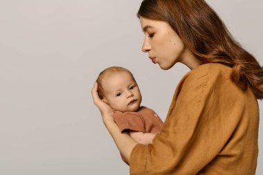Güzel, genç bir anne, birlikte hassas bir anı paylaşırken küçük çocuğuna sevgiyle bakar..