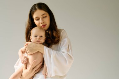 Genç bir anne sevgiyle çocuğunu kucaklar, derin bağlarını ve neşelerini vurgular..