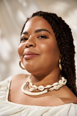 Kendine güvenen bir kadın zarif bir şekilde çiçeklerin arasında poz verir, tarzını ve güzelliğini sergiler..