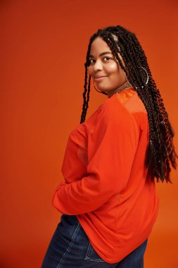 Güzel örgülü bir kadın, kendine güvenerek şık bir kıyafet içinde, mutluluk saçar..