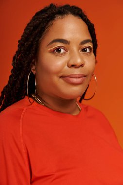Örgülü Afro-Amerikalı kadın moda kıyafetiyle hava atıyor, çeşitliliği ve güzelliği kutluyor..