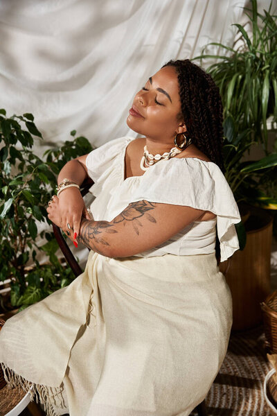 A pretty african american woman with braids exudes bliss in a summer dress surrounded by greenery.