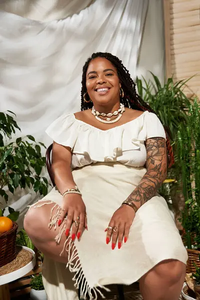 Saçlı güzel bir zenci kadın yeşil bitkilerin arasında güneşli bir günün tadını çıkarıyor..