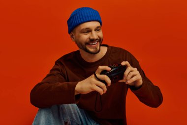 Mavi bereli gülümseyen genç adam rahat bir yerde otururken anılarını yakalıyor..