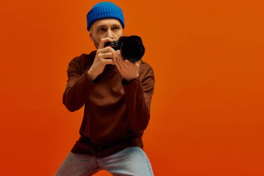 Yakışıklı genç bir adam fotoğraf makinesiyle poz veriyor, eşsiz sanatsal anları çekmeye hazır..