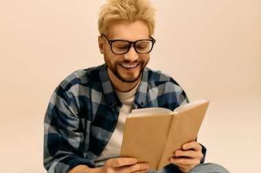 Işıl ışıl aydınlık uzay gösterileri yakışıklı genç bir adam kitap okurken neşeyle gülümsüyor..