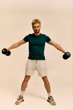 Yakışıklı adam ağırlık kaldırırken güç ve adanmışlık gösteriyor, spor yapmaya odaklanıyor..