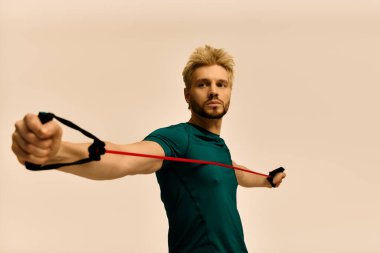 Yakışıklı genç adam direniş bantlarını kararlılıkla esnetiyor ve modern bir ortama odaklanıyor.