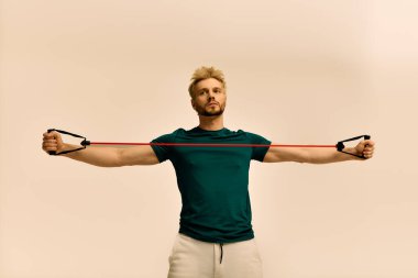 Kendine güveni olan genç bir adam elastik bantlarla direnç egzersizleri yapıyor..