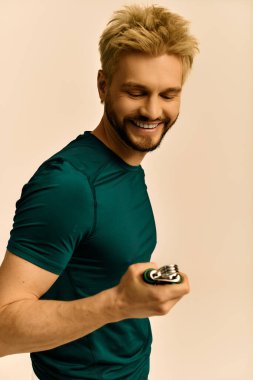 Sarı saçlı neşeli genç bir adam sıcak bir atmosferde modern bir aletle etkileşimden hoşlanıyor..