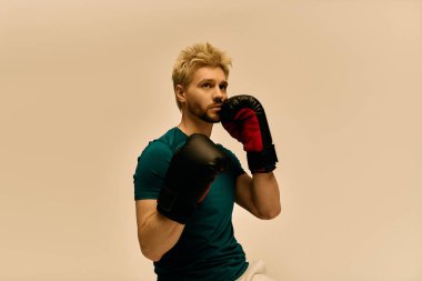 Yeşil gömlekli yakışıklı bir genç boks eldivenlerini giyer ve eğitime hazırlanır..