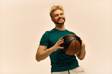 Neşeli genç bir adam bir basketbol topuyla poz veriyor, gülümserken kendine güveni ve enerjisi yayılıyor.