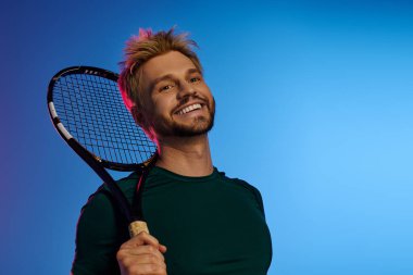 Çekici bir genç adam tenise olan sevgisini gösteriyor, pozitif enerji yayıyor..