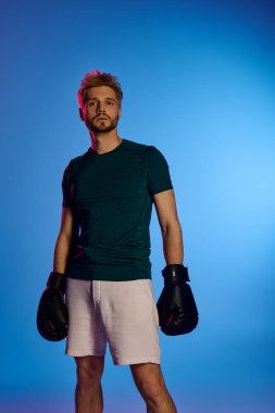 Şık bir genç adam kendine güvenen bir boks eldiveniyle, canlı bir mekanda maç için hazır bekliyor..