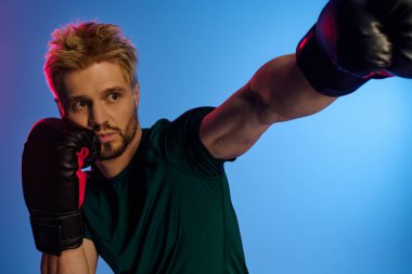 Yakışıklı bir genç adam yoğun bir şekilde antrenman yapıyor, boks eldivenlerinde odaklanma ve beceri gösteriyor..