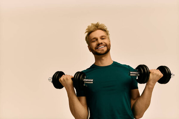 Спортивный молодой человек широко улыбается, поднимая тяжести в помещении, проявляя энтузиазм к фитнесу.