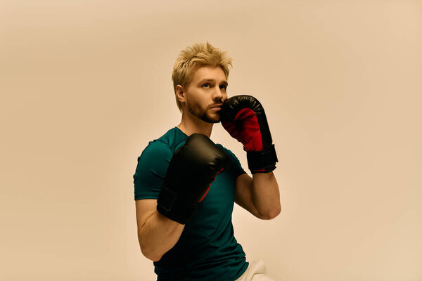 Красивый молодой человек в зеленой рубашке надевает боксерские перчатки, готовясь к тренировкам.