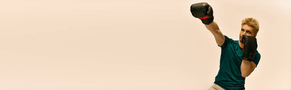 Молодой человек упорно тренируется, демонстрируя свои боксерские способности и силу в современном спортзале.