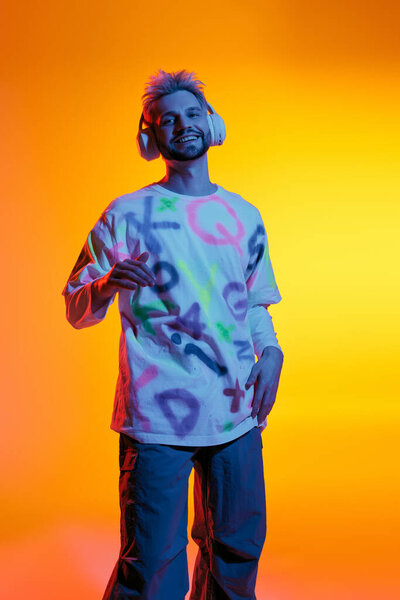 A handsome young man in a playful outfit is joyfully immersed in music, radiating energy.