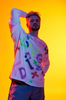 Yakışıklı genç adam cesur bir duruş sergiliyor, eşsiz bir sanatsal stil ve canlı bir enerji sergiliyor..