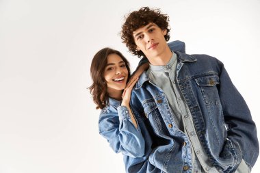 Neşeli genç çift, eşgüdümlü bir kot giyerken sevgilerini sergiliyor..