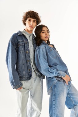 Şık bir çift, kot kıyafetleri içinde birlikte poz verirken aşk ve tarz yayar..
