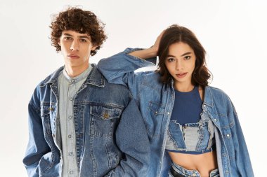 Genç bir çift birlikte poz veriyor. Parlak bir stüdyoda sevgi ve moda kıyafetleri sergiliyorlar..