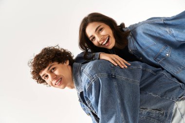 Neşeli genç çift, modaya uygun kot kıyafetlerle kahkahalar ve şakalaşmalar paylaşıyor..