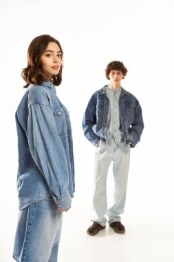 Şık bir çift yan yana durur, modern kot kıyafetleriyle romantizm yayarlar, sevgilerini sergilerler..