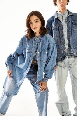 Genç bir çift moda anlayışlarını moda kıyafetleri içinde neşeli bir pozla sergiliyor..