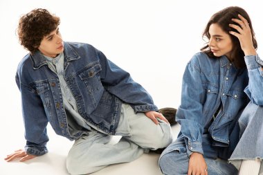 Moda kot ceketli genç çift rahat ortamında neşeli bir anı paylaşıyor..