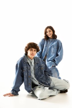 Şık genç bir çift, parlak bir zemine karşı şık bir kotla aşk yayıyor..