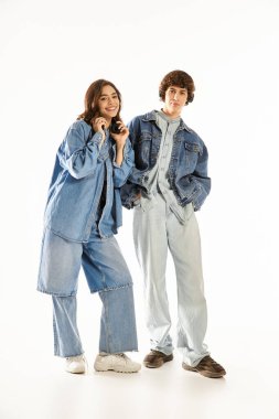 Parlak bir mekanda birbirlerine eşlik eden ve gülümseyen şık kotlar giymiş sevimli bir çift..