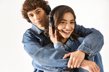 Bir çift genç aşık güven içinde birbirini kucaklarken müzik dinlemekten zevk alırlar..