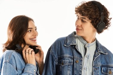 Genç çift, neşeli ve neşeli bir atmosferde birlikte müzik dinlerken birbirlerine gülümsüyor..