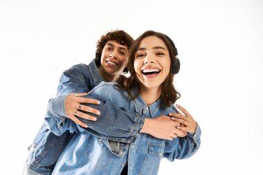 Kot ceketli neşeli genç çift, parlak bir mekanda müzik ve kahkahaların tadını çıkarıyor..