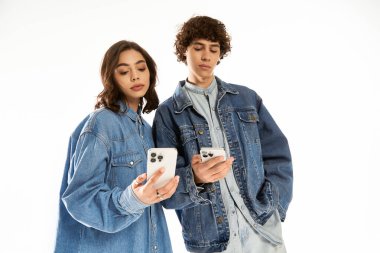 Moda çifti, akıllı telefonlarına parlak bir mekanda bakarken neşeli bir an yaşıyor..