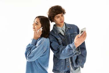 Genç bir çift mutlu bir anı paylaşırken şık bir şekilde telefonlarına odaklanıyor..