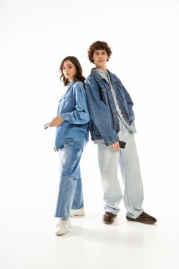 Şık bir kadın ve erkek birlikte durur, şık bir kot giyerek aşklarını sergilerler..