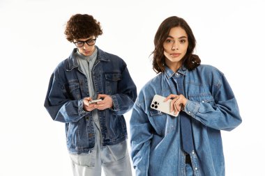 Modaya uygun genç bir çift, modaya uygun kıyafetlerini sergilerken neşeli bir gülümsemeyle sevgilerini ifade eder..