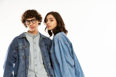 Son moda genç çift birlikte poz veriyor, kot kıyafetlerine sevgi ve güven yayıyorlar..