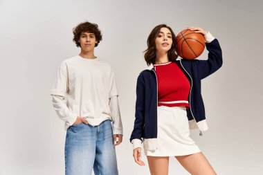 Modaya uygun genç bir çift basketbol topuyla rahatça poz veriyor..