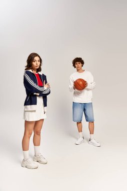 Genç çift, neşeli bir şekilde basketbol oynamaya hazırlanırken şık aşklarını ifade ederler..