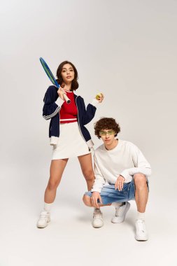 Genç çift, tenis kıyafetleriyle eğlenip, tarzlarını ve sevgilerini sergiliyorlar..